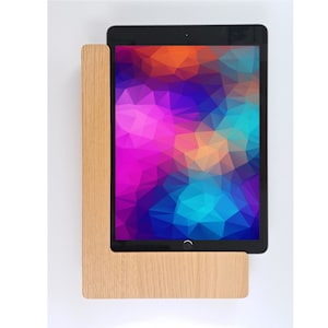May include: A wooden stand with a cutout for a tablet. The tablet is displaying a colorful geometric pattern.