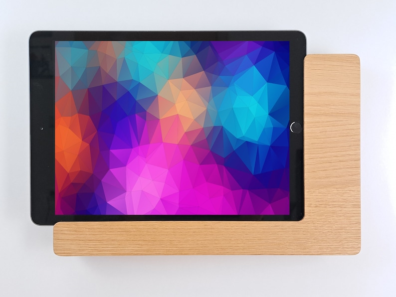 May include: A tablet computer with a colorful geometric pattern on the screen is resting on a wooden stand.