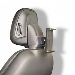 Può includere: Supporto per poggiatesta per auto argentato con supporto per telefono. Il supporto è progettato per essere fissato al poggiatesta di un sedile auto. Il supporto per telefono è regolabile e può contenere una varietà di dimensioni di telefono.