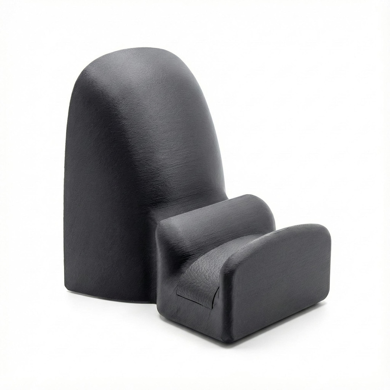 K&ouml;nnte beinhalten: Ein schwarzer, ergonomischer Telefonst&auml;nder mit gebogener R&uuml;ckseite und einer Halterung f&uuml;r das Telefon. Der St&auml;nder besteht aus einem matten Material und hat eine glatte Textur. Das Design ist modern und minimalistisch, geeignet f&uuml;r einen Schreibtisch oder Nachttisch.