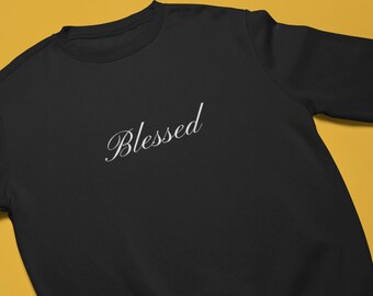 May include: Black sweatshirt with the word "Blessed" in white cursive lettering.
