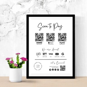 May include: A black-framed sign with a white background featuring the text Scan To Pay, three QR codes for Venmo, Apple Pay, and PayPal, a We also Accept section with payment icons, and a Let's Connect section with a website and social media QR code.