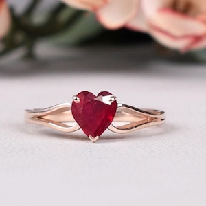 Peut inclure: Une bague en or avec un rubis en forme de cœur. La bague est dotée d'une monture à double bande et d'une finition polie.