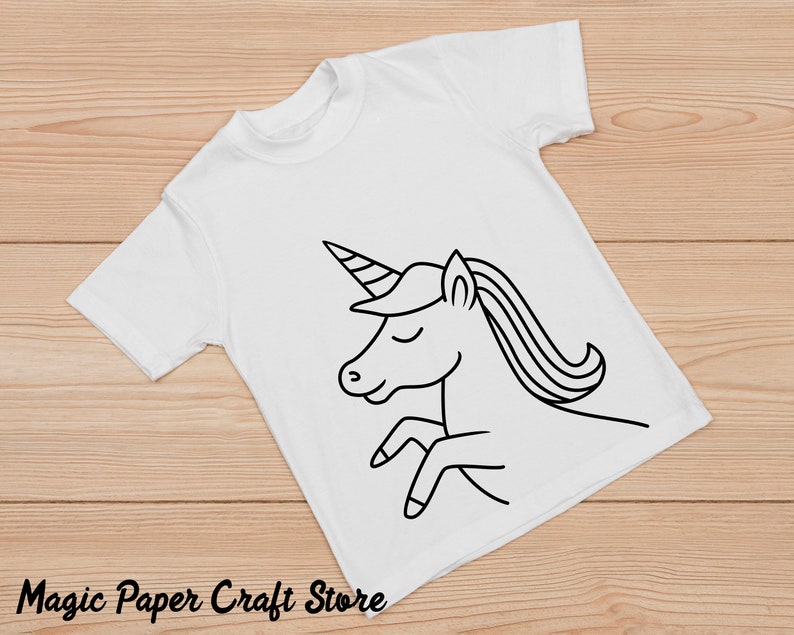 May include: A white t-shirt with a black line drawing of a unicorn on it. The unicorn has a horn, mane, and tail.