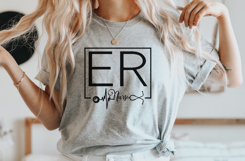 May include: Gray t-shirt with a black graphic design that says "ER Nurse" with a stethoscope and a heartbeat graphic.