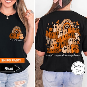 May include: Black t-shirt with an orange and brown graphic design that says "In November We Wear Orange For CRPS #complex regional pain syndrome" on the back and "CRPS awareness" on the front.