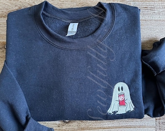 May include: Black sweatshirt with a white ghost holding a red can with the text "Pepsi" on it.