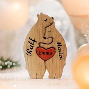 Könnte beinhalten: Holzfigur eines Bärenpaares, das sich umarmt. In der Mitte befindet sich ein Herz mit der Aufschrift "Emma". Die Bären sind mit den Namen "Ralf" und "Marleen" beschriftet.