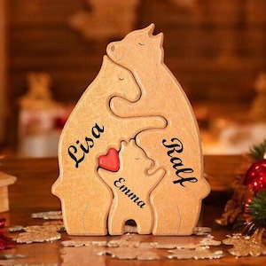 Könnte beinhalten: Holzpuzzle einer dreiköpfigen Bärenfamilie, mit den Namen Lisa, Ralf und Emma auf jedem Bären. Die Bären umarmen sich und haben ein rotes Herz in der Mitte.