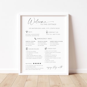 May include: A framed white sign with black text that reads "Welcome to the Cottage." The sign includes WiFi information, contact details, emergency info, house rules, and check-out instructions. The sign is on a wooden floor.