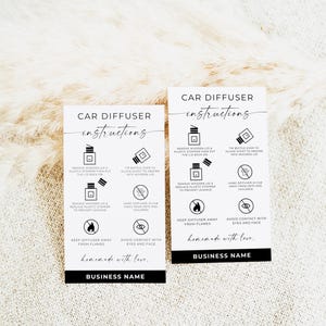 May include: Two black and white instruction cards for car diffusers. The cards feature diagrams and text explaining how to use the product, including steps for removing the lid and avoiding flames. The phrase "homemade with love" is also included.