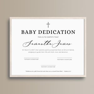 May include: A framed baby dedication certificate with a cross at the top. The text reads "BABY DEDICATION" and "THIS IS TO CERTIFY THAT" followed by a name. Includes spaces for signatures and a Bible verse.
