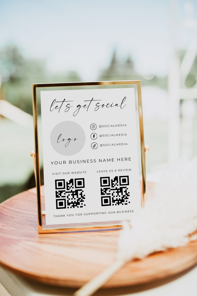 May include: White sign with a gold frame, the text "let's get social" and a logo placeholder.  Social media icons with handles for Instagram, Facebook, and TikTok.  QR codes for visiting the website and leaving a review.  The text "YOUR BUSINESS NAME HERE" and "THANK YOU FOR SUPPORTING OUR BUSINESS".