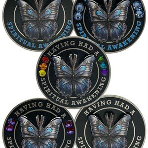May include: Five black circular tokens featuring a butterfly design and the text "HAVING HAD A SPIRITUAL AWAKENING". Some tokens have colourful gemstones around the edge.