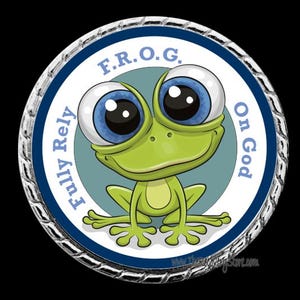 May include: A circular badge with a cartoon frog design. The frog is green with big blue eyes, set against a light blue backdrop. The text around the frog reads "F.R.O.G. Fully Rely On God". The badge has a silver edge.