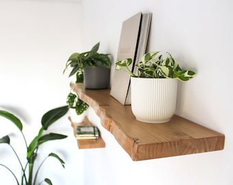 Zwevende plank van massief hout. Wandplank met verborgen beugels. Rustieke plank met natuurlijke randen.