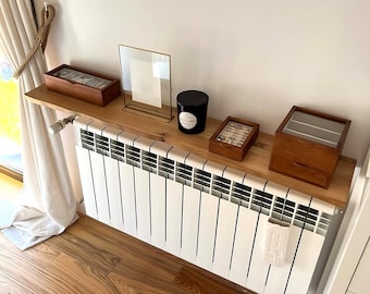 Houten plank met een rechte rand om een radiator af te dekken. Zwevende wandplank.