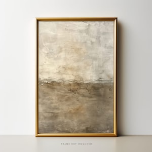 May include: Abstract painting in a gold frame. The painting features a light brown and white color scheme with a textured, brushstroke effect. The top half of the painting is a lighter shade of brown with white brushstrokes, while the bottom half is a darker shade of brown with a more textured look.
