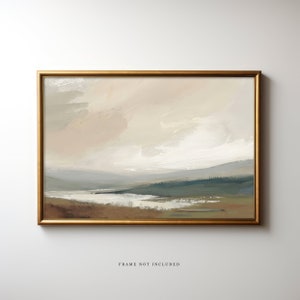 May include: A framed painting of a landscape with a light brown, gray, and blue color scheme. The painting depicts a body of water in the foreground, with hills and trees in the background. The sky is a light brown color with white clouds. The painting is framed in a gold frame. The text 'FRAME NOT INCLUDED' is printed below the painting.