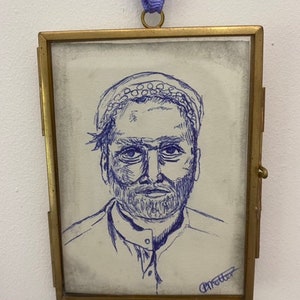May include: A framed drawing of a man with a beard and a patterned head covering. The drawing is done in blue ink on a white background. The frame is gold and has a glass front. The artist's signature, "Procter", is in the bottom right corner.