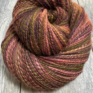 Handspun “Red Alder”  Heathered BFL Wool yarn in shades of pink, green and purple.