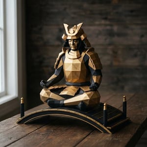 May include: A geometric sculpture of a samurai in a seated meditation pose, featuring a faceted gold and black armour design. The figure rests upon a curved black bridge-like base with gold accents, showcasing sharp angular planes and a metallic finish.