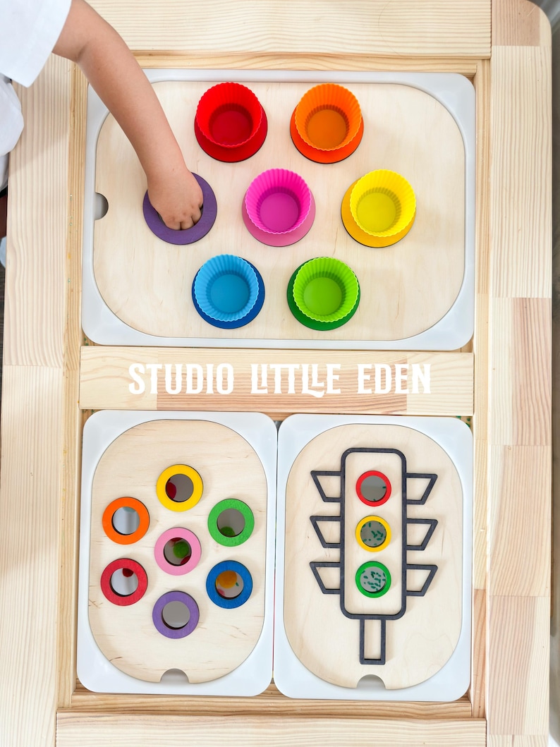 May include: Wooden activity center with multiple sensory play areas.  The top section features a rainbow of silicone cups, the middle section has a colorful ring sorting game, and the bottom section has a traffic light with colored circles.