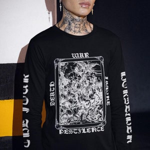 May include: A black long-sleeve shirt with a white graphic print of a tarot card. The card depicts a scene of war, famine, death, and pestilence. The text on the card reads "WAR, FAMINE, DEATH, PESTILENCE".