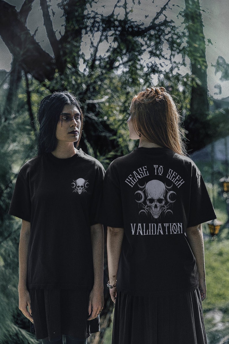 K&ouml;nnte beinhalten: Zwei Personen tragen schwarze T-Shirts mit einem Totenkopf-Motiv und dem Text "Cease to Seek Validation".
