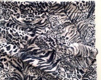 May include: A black and white faux fur throw blanket with a zebra and leopard print pattern.
