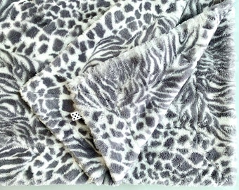 May include: A soft, plush blanket with a gray and white zebra and leopard print pattern.