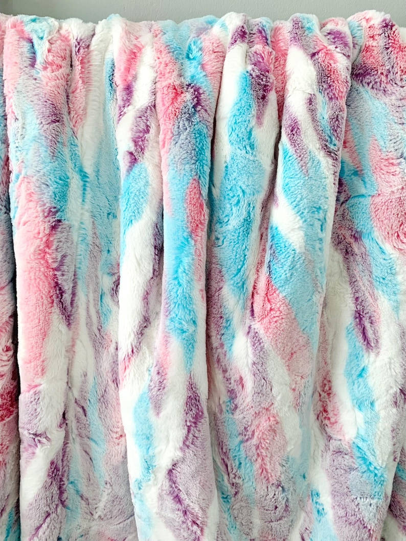 May include: A soft, plush throw blanket with a tie-dye pattern in shades of pink, blue, and purple.
