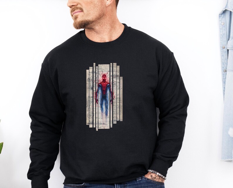 Op de afbeelding: Zwart sweatshirt met lange mouwen met een afbeelding van een superheld in een rood en blauw pak. De superheld is afgebeeld in een rechthoekig ontwerp met verticale lijnen en een vintage papieren achtergrond. De sweatshirt is gemaakt van zacht materiaal.