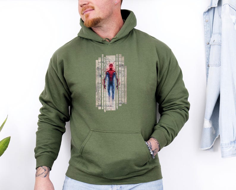 K&ouml;nnte beinhalten: Olivgr&uuml;ner Kapuzenpullover mit einer Vordertasche. Die Grafik auf der Vorderseite zeigt eine Aquarellillustration eines Superhelden in einem rot-blauen Anzug, vor dem Hintergrund architektonischer Baupl&auml;ne.