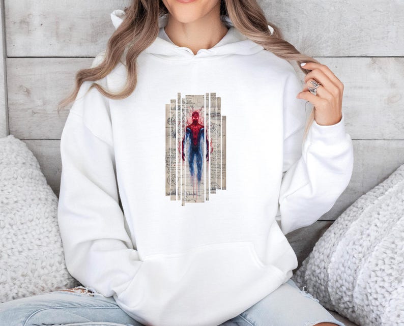 K&ouml;nnte beinhalten: Wei&szlig;er Kapuzenpullover mit einem Spiderman-Motiv. Das Motiv zeigt Spiderman in einem rot-blauen Anzug vor einem Hintergrund im Vintage-Stil. Der Kapuzenpullover ist aus weichem Material und hat ein klassisches Design.