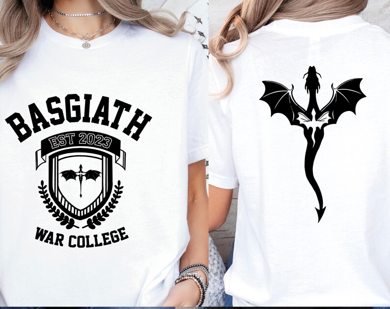 May include: White t-shirt with a black graphic design featuring the text "BASGIATH EST 2023 WAR COLLEGE" and a shield with a dragon inside. The back of the shirt features a black dragon design.
