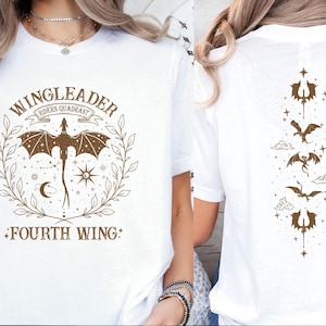 Pode incluir: Camiseta branca com um gr&aacute;fico marrom de um drag&atilde;o e o texto "Wingleader Riders Quadrant Fourth Wing". A parte de tr&aacute;s da camiseta tem uma linha vertical de cinco drag&otilde;es marrons.