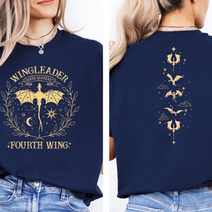 Pode incluir: Uma camiseta azul marinho com um gr&aacute;fico dourado de um drag&atilde;o e o texto "WINGLEADER RIDERS QUADRANT +FOURTH WING+"
