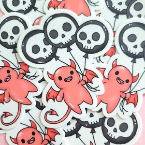 May include: A collection of stickers featuring cute red cartoon devils holding black and white skull balloons. The stickers are on a pink background.