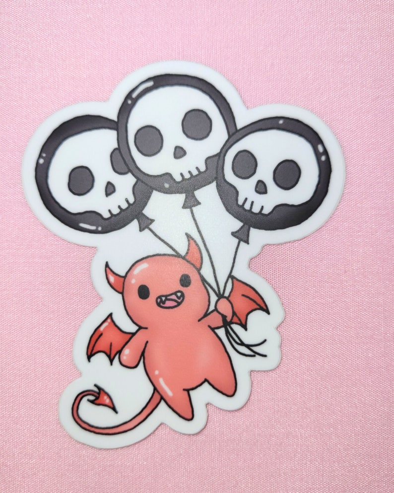 May include: A red cartoon devil with horns and wings holding three black and white skull balloons.