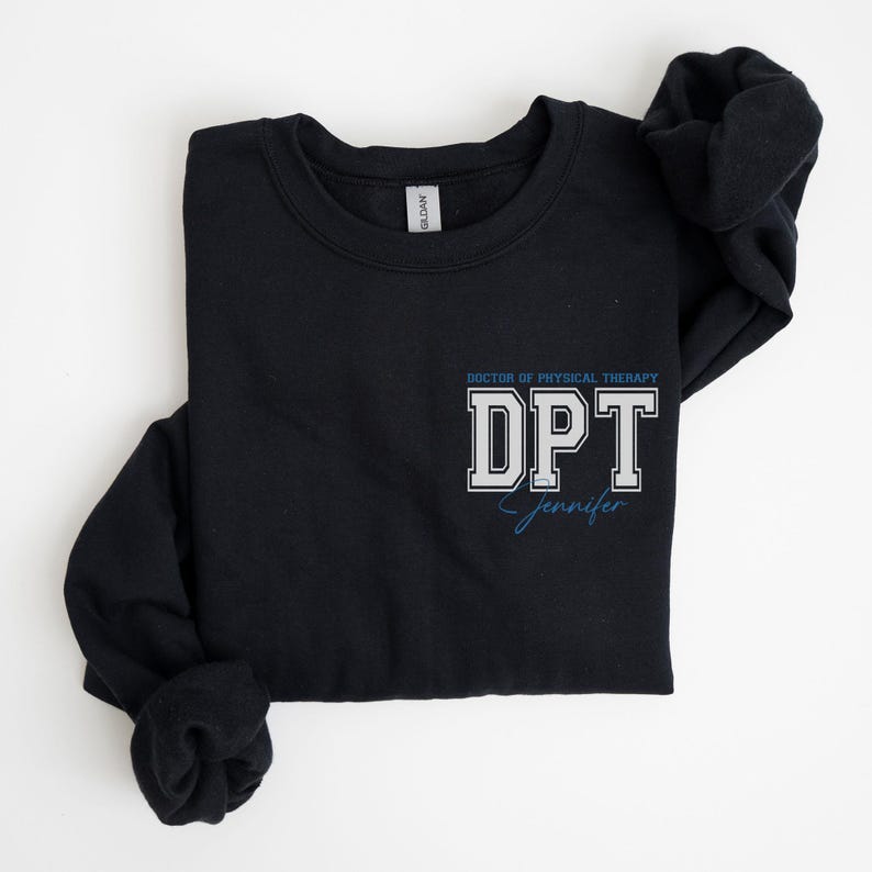 Puede incluir: Sudadera negra con un texto blanco "Doctor of Physical Therapy DPT" y una firma azul "Jennifer".