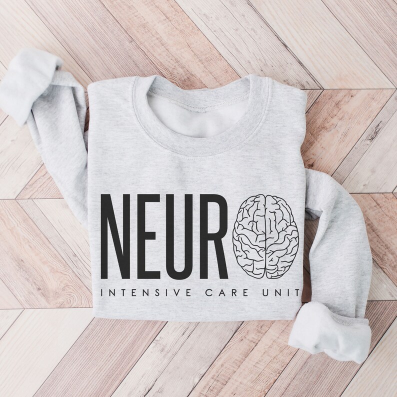 Puede incluir: Una sudadera gris con el texto "NEURO INTENSIVE CARE UNIT" y un gr&aacute;fico de cerebro.