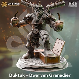May include: A miniature figurine of a bearded dwarven grenadier named Duktuk, wearing metallic armor with two cannons mounted on the back. The figure holds a spherical grenade in each hand and stands on a circular base next to an open crate.