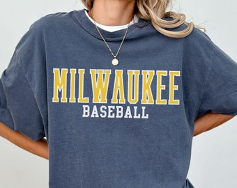 May include: An oversized dark blue t-shirt with a yellow graphic that says "MILWAUKEE BASEBALL".