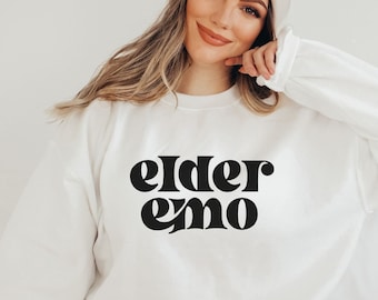 May include: White sweatshirt with black text that reads "elder emo".