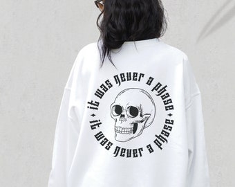 May include: White sweatshirt with a black skull graphic and the text "It was never a phase" repeated around the skull.
