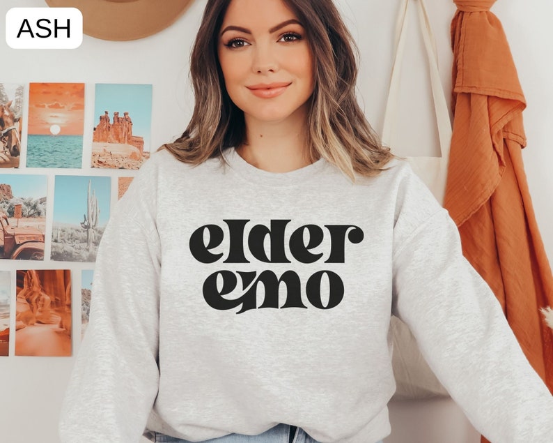 May include: A grey sweatshirt with the text "elder emo" printed in black retro-style lettering.