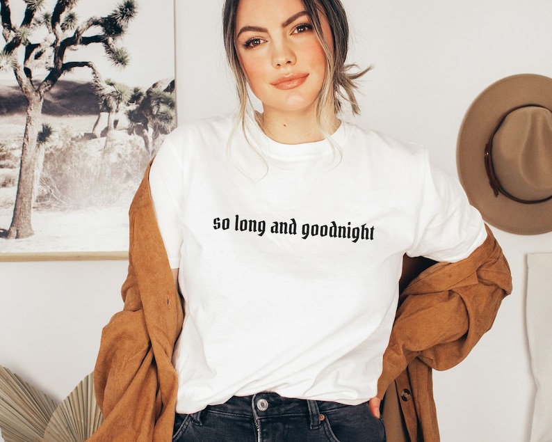 May include: White t-shirt with the text "so long and goodnight" printed in black.