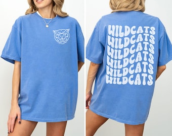 May include: A blue oversized t-shirt with a white graphic of a wildcat on the front and the word "WILDCATS" repeated in a retro font on the back.