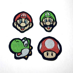 May include: Four embroidered patches featuring characters from the Super Mario video game series. The patches include Mario, Luigi, Yoshi, and a Super Mushroom, each with detailed stitching and vibrant colours. The patches have a black border.